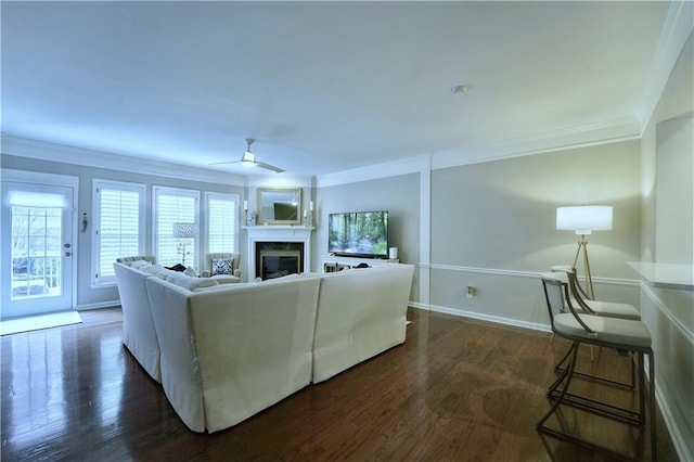 living room featuring dark hardwood / wood-style floors, ceiling fan, and ornamental molding