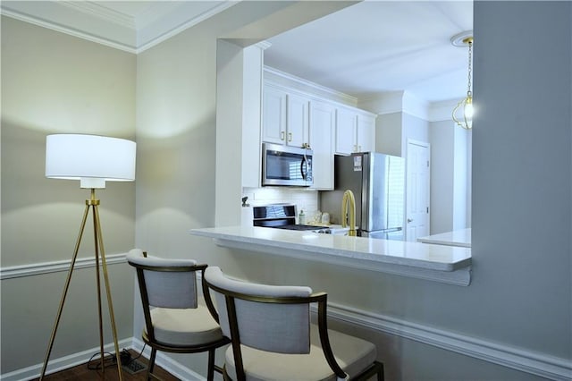 kitchen with white cabinets, a breakfast bar area, ornamental molding, tasteful backsplash, and stainless steel appliances