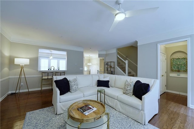 living room featuring hardwood / wood-style floors, ceiling fan, sink, and crown molding