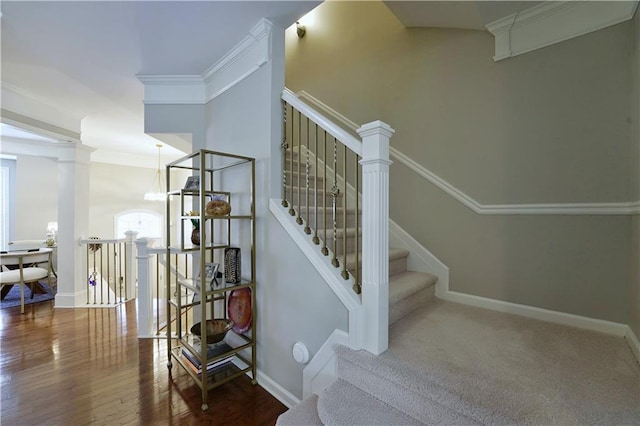 staircase featuring hardwood / wood-style floors, a notable chandelier, and crown molding