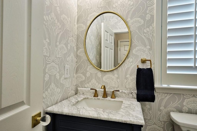 bathroom featuring vanity, toilet, and wallpapered walls