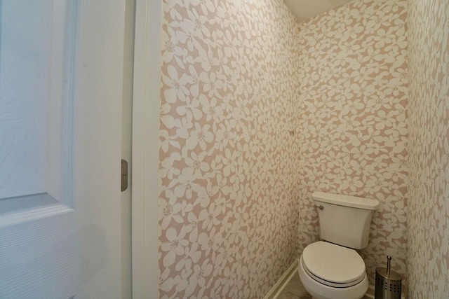 bathroom featuring toilet and wallpapered walls