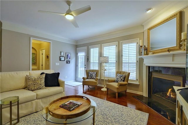 living room with hardwood / wood-style floors, ceiling fan, ornamental molding, and a high end fireplace