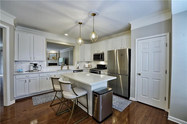 kitchen with a kitchen breakfast bar, white cabinetry, and stainless steel appliances