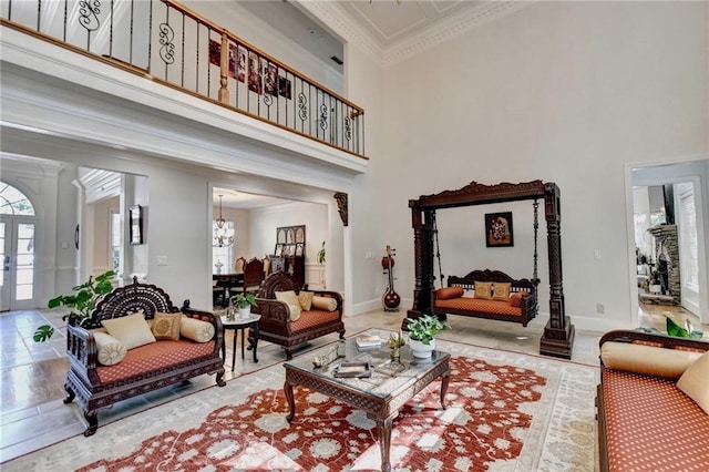 interior space with crown molding, a high ceiling, an inviting chandelier, and baseboards