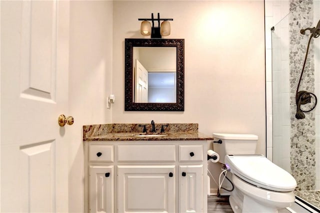 bathroom featuring vanity, a baseboard radiator, a shower stall, and toilet