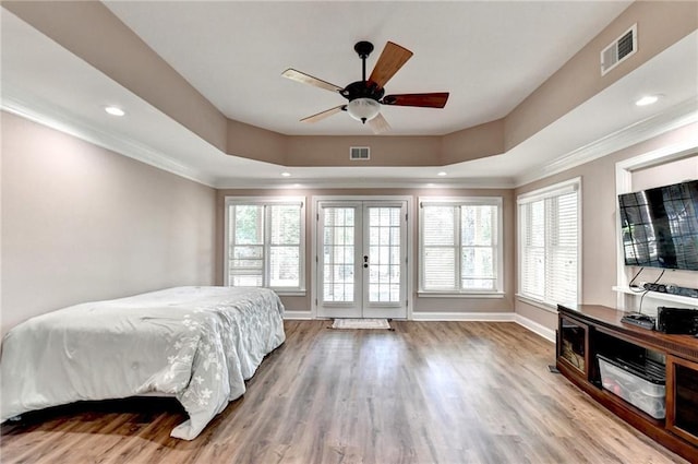 bedroom featuring crown molding, french doors, wood finished floors, and visible vents