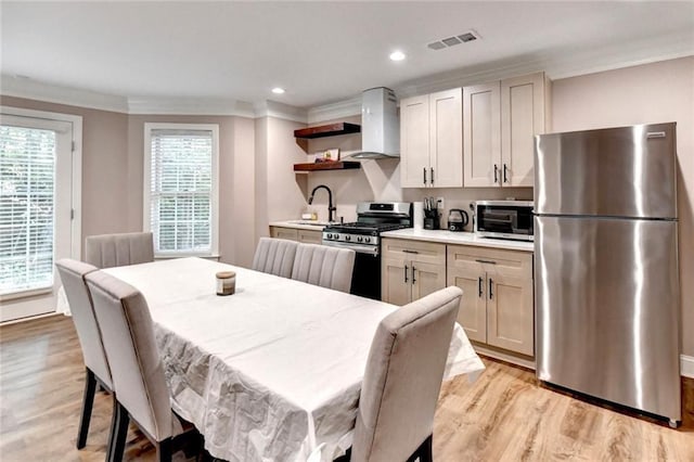 kitchen with open shelves, a sink, wall chimney exhaust hood, stainless steel appliances, and visible vents
