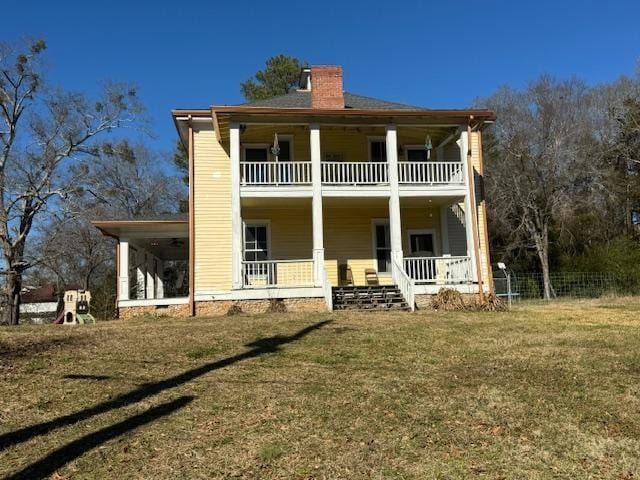 back of house featuring a porch, a yard, and a balcony