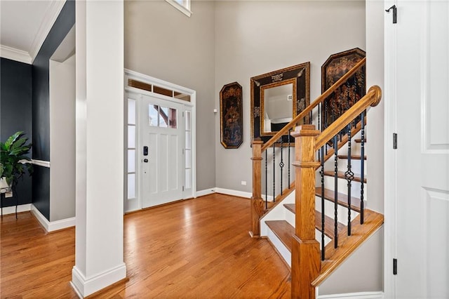 entryway with wood-type flooring and crown molding