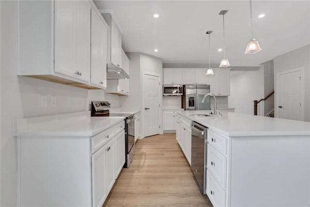 kitchen featuring white cabinetry, an island with sink, appliances with stainless steel finishes, and pendant lighting