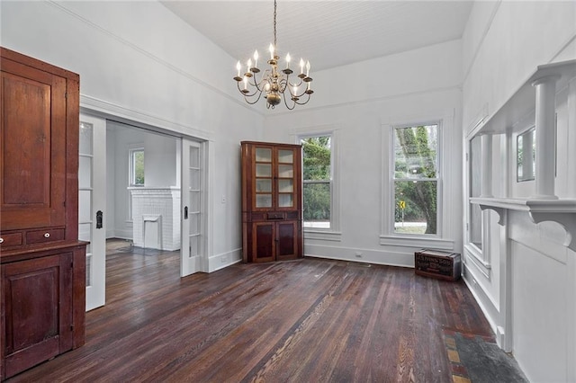 unfurnished dining area with built in shelves, dark wood-type flooring, and a chandelier