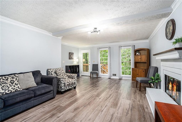 1879 Beaver Dam Ln NE, Marietta, GA 30062 - living area with a glass covered fireplace, wood finished floors, a textured ceiling, crown molding, and baseboards