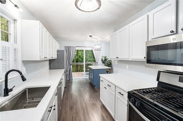1879 Beaver Dam Ln NE, Marietta, GA 30062 - kitchen with appliances with stainless steel finishes, a sink, white cabinets, dark wood finished floors, and a chandelier