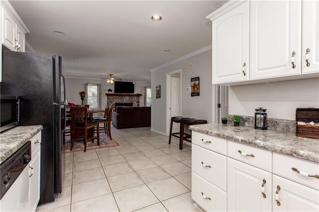 kitchen featuring white appliances, light tile patterned floors, ornamental molding, light stone counters, and white cabinets