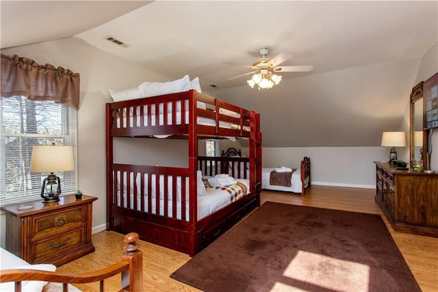 bedroom with ceiling fan, light wood-type flooring, and vaulted ceiling