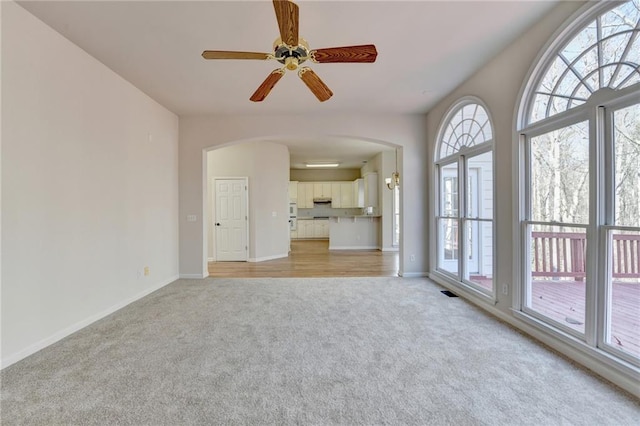 1924 Wilkenson Xing, Marietta, GA 30066 - unfurnished living room featuring light colored carpet, arched walkways, baseboards, and ceiling fan