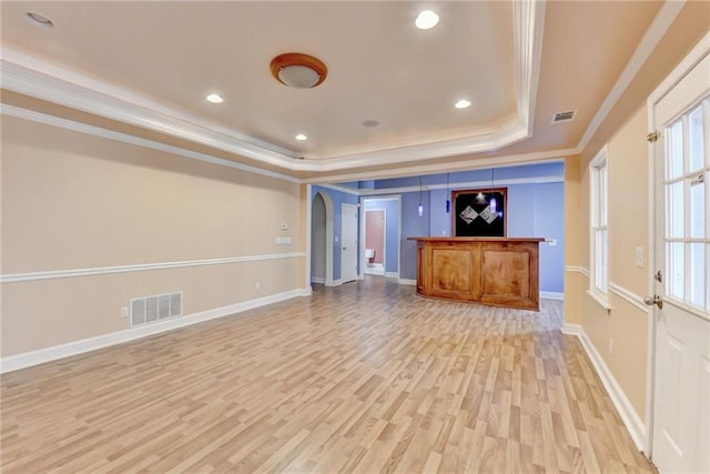 1924 Wilkenson Xing, Marietta, GA 30066 - unfurnished living room featuring a raised ceiling, ornamental molding, light wood-style floors, baseboards, and arched walkways