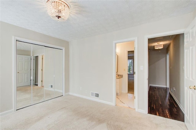 unfurnished bedroom with carpet floors, a textured ceiling, and a closet