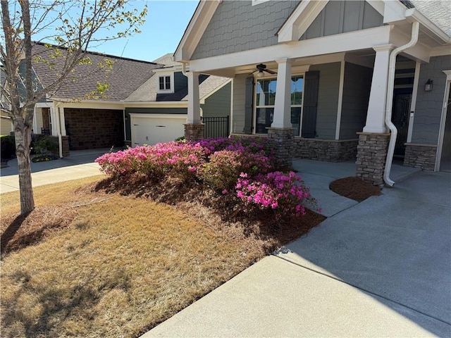 exterior space with a porch, board and batten siding, a garage, stone siding, and concrete driveway