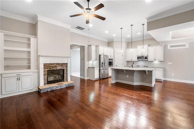 kitchen featuring a breakfast bar area, appliances with stainless steel finishes, white cabinets, visible vents, and a ceiling fan