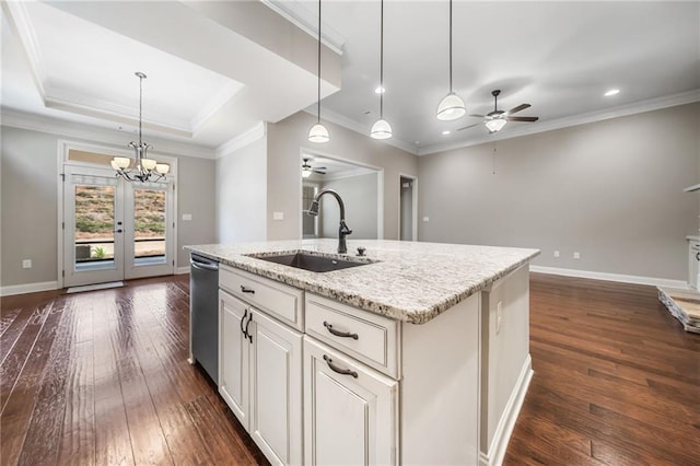kitchen featuring a sink, baseboards, dark wood finished floors, a center island with sink, and ceiling fan with notable chandelier
