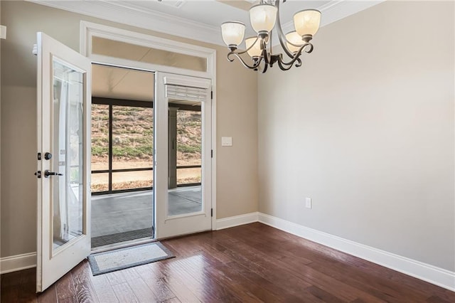doorway featuring a chandelier, baseboards, dark wood finished floors, and crown molding