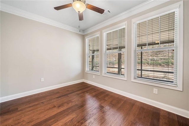 spare room with ceiling fan, crown molding, visible vents, baseboards, and dark wood finished floors