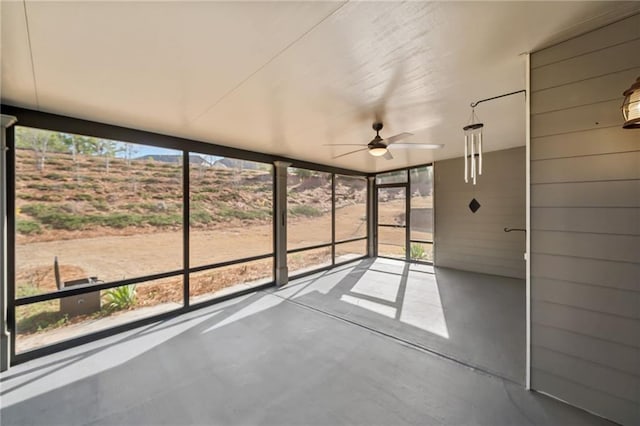 unfurnished sunroom with ceiling fan