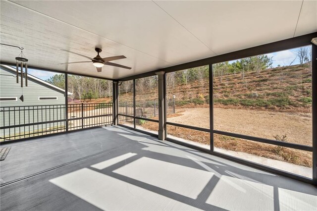 unfurnished sunroom with a ceiling fan