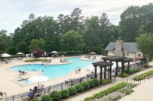 pool with a patio area and fence