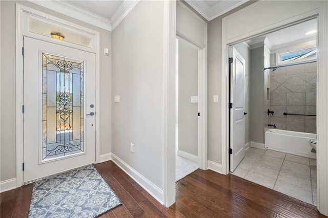 entrance foyer with wood finished floors, crown molding, and baseboards