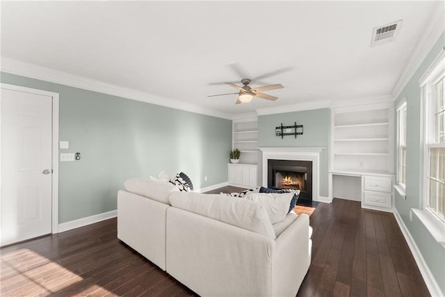 living room featuring ornamental molding, dark hardwood / wood-style floors, built in features, and ceiling fan