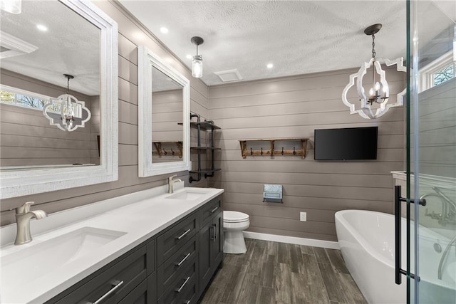 full bathroom with hardwood / wood-style floors, a chandelier, vanity, separate shower and tub, and a textured ceiling