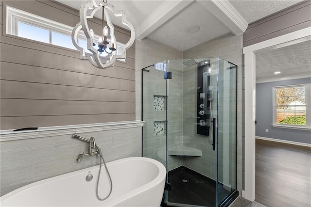 bathroom with an inviting chandelier, independent shower and bath, and hardwood / wood-style floors