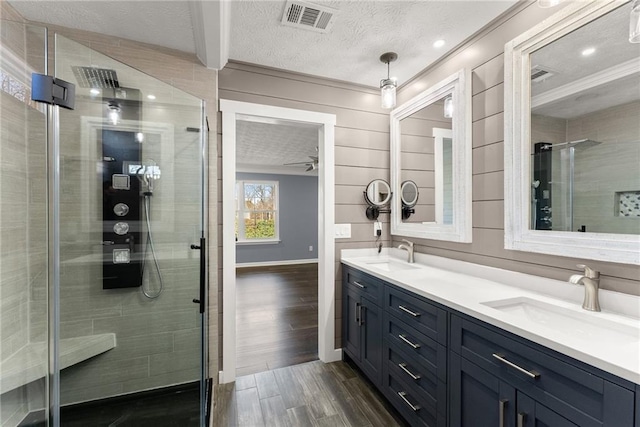 bathroom featuring vanity, a textured ceiling, and walk in shower