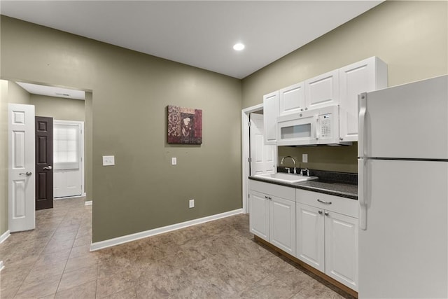 kitchen featuring sink, white appliances, and white cabinets