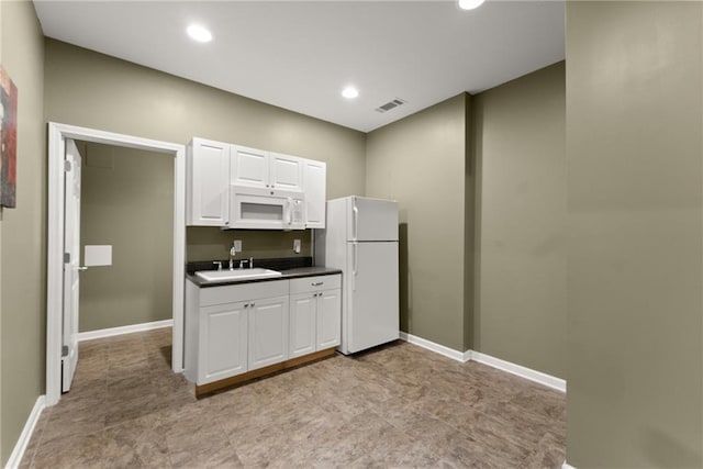 kitchen featuring white cabinetry, sink, and white appliances