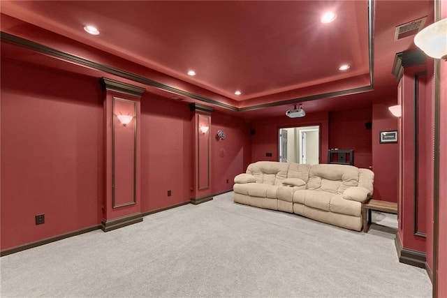 cinema room with light carpet and a tray ceiling