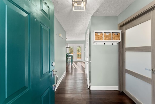 mudroom featuring dark wood-type flooring and a textured ceiling