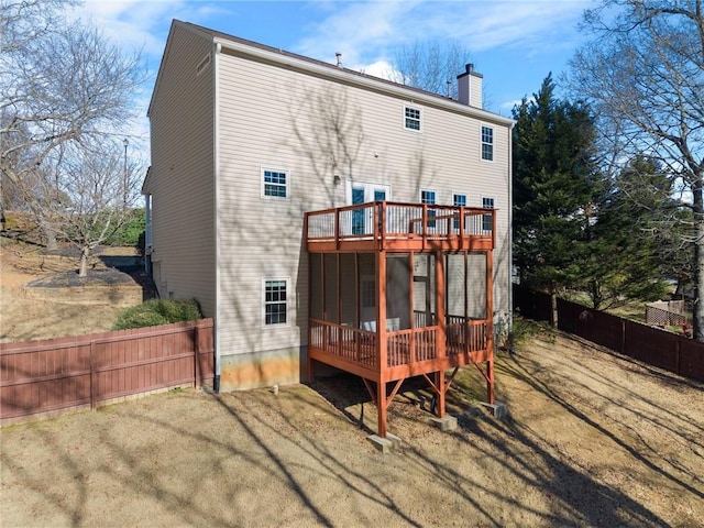 rear view of house with a sunroom and a yard