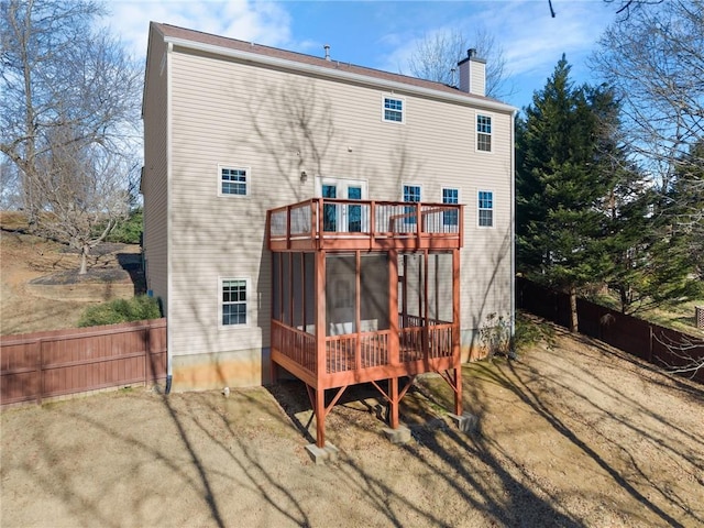 rear view of property featuring a sunroom