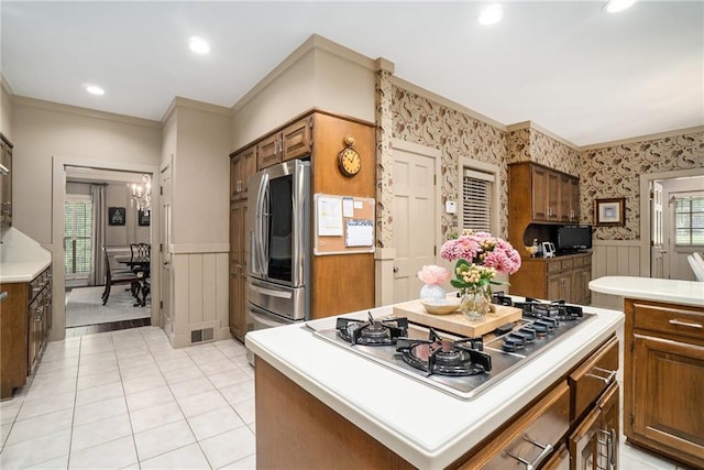 2080 Old Dominion Rd, Atlanta, GA 30350 - kitchen featuring a wainscoted wall, appliances with stainless steel finishes, crown molding, light countertops, and brown cabinetry