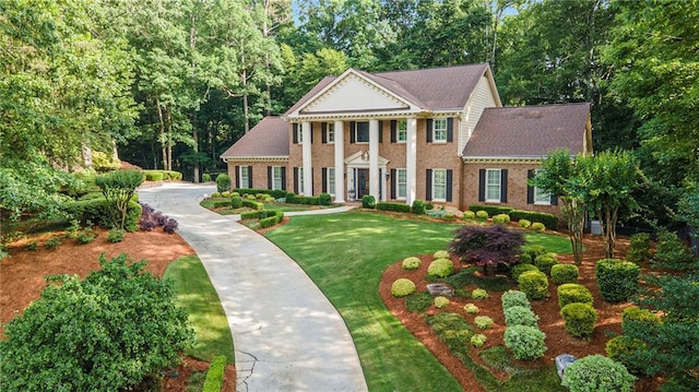 2080 Old Dominion Rd, Atlanta, GA 30350 - greek revival house featuring a front yard, view of wooded area, and brick siding