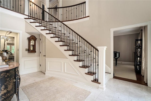 2080 Old Dominion Rd, Atlanta, GA 30350 - staircase with a high ceiling, wainscoting, a decorative wall, and baseboards
