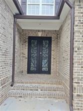 entrance to property featuring brick siding