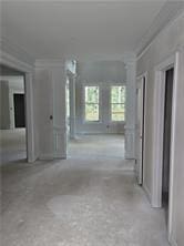 hallway featuring concrete flooring and ornamental molding