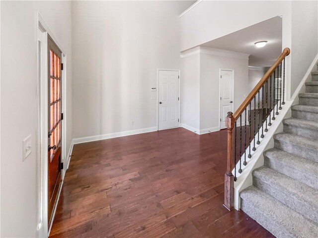 entrance foyer featuring dark hardwood / wood-style flooring and crown molding