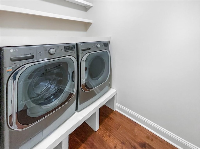 clothes washing area with independent washer and dryer and dark hardwood / wood-style flooring