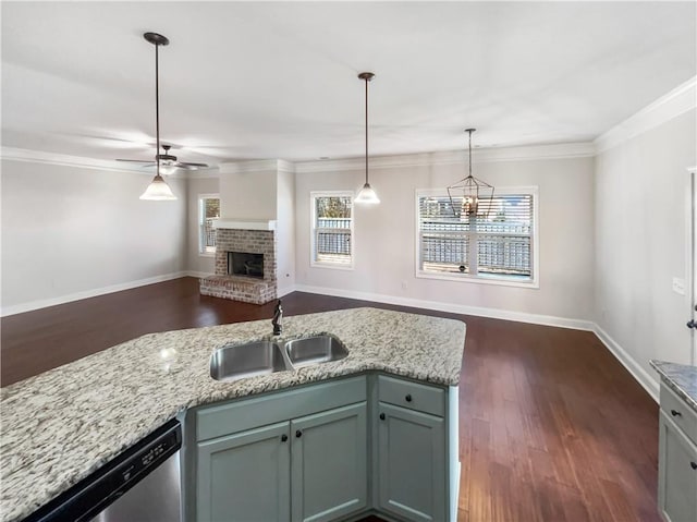 kitchen with ceiling fan, sink, light stone counters, stainless steel dishwasher, and a fireplace